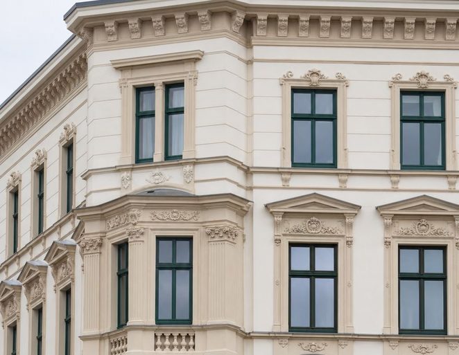 Sanierte Gründerzeitfassade in Leipzig mit Eckerker, Stuckornamentik und dunkelgrünen Sprossenfenstern